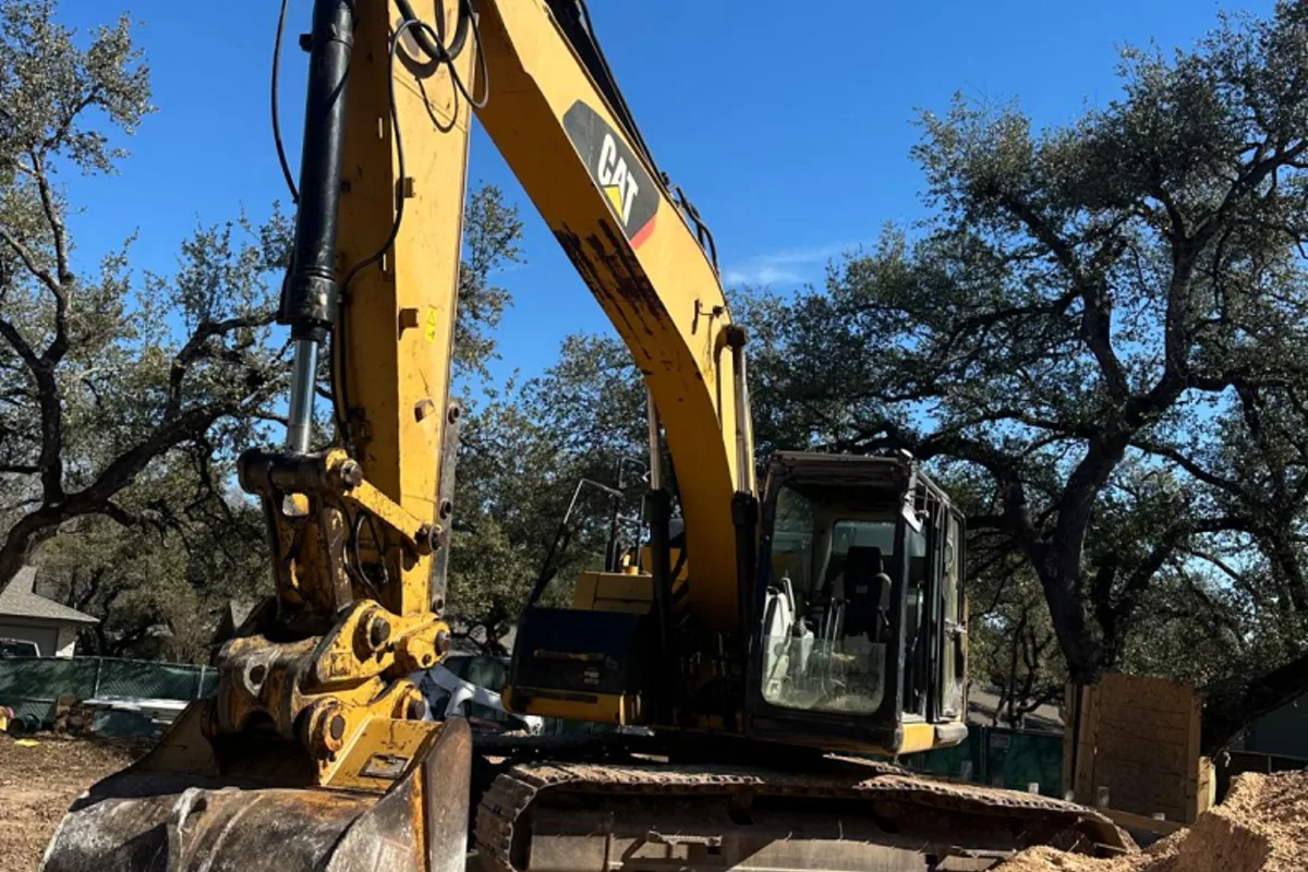 Excavator removing failed concrete before replacement in Central Texas